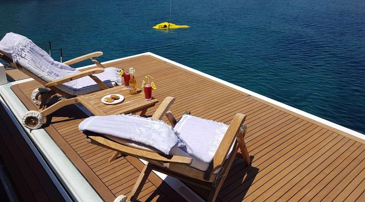 a deck with a table and chairs on it aboard SEA LION II Yacht for Charter