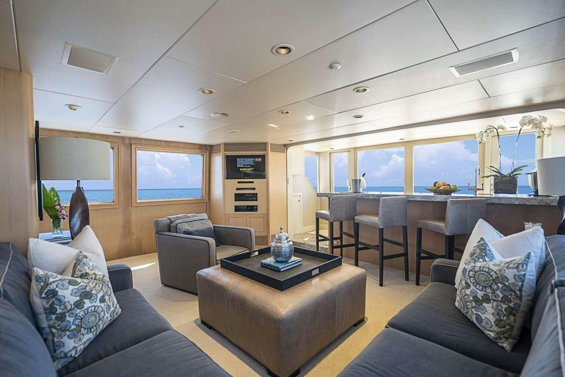 a living room with leather couches and a large window aboard CHERISH Yacht for Charter