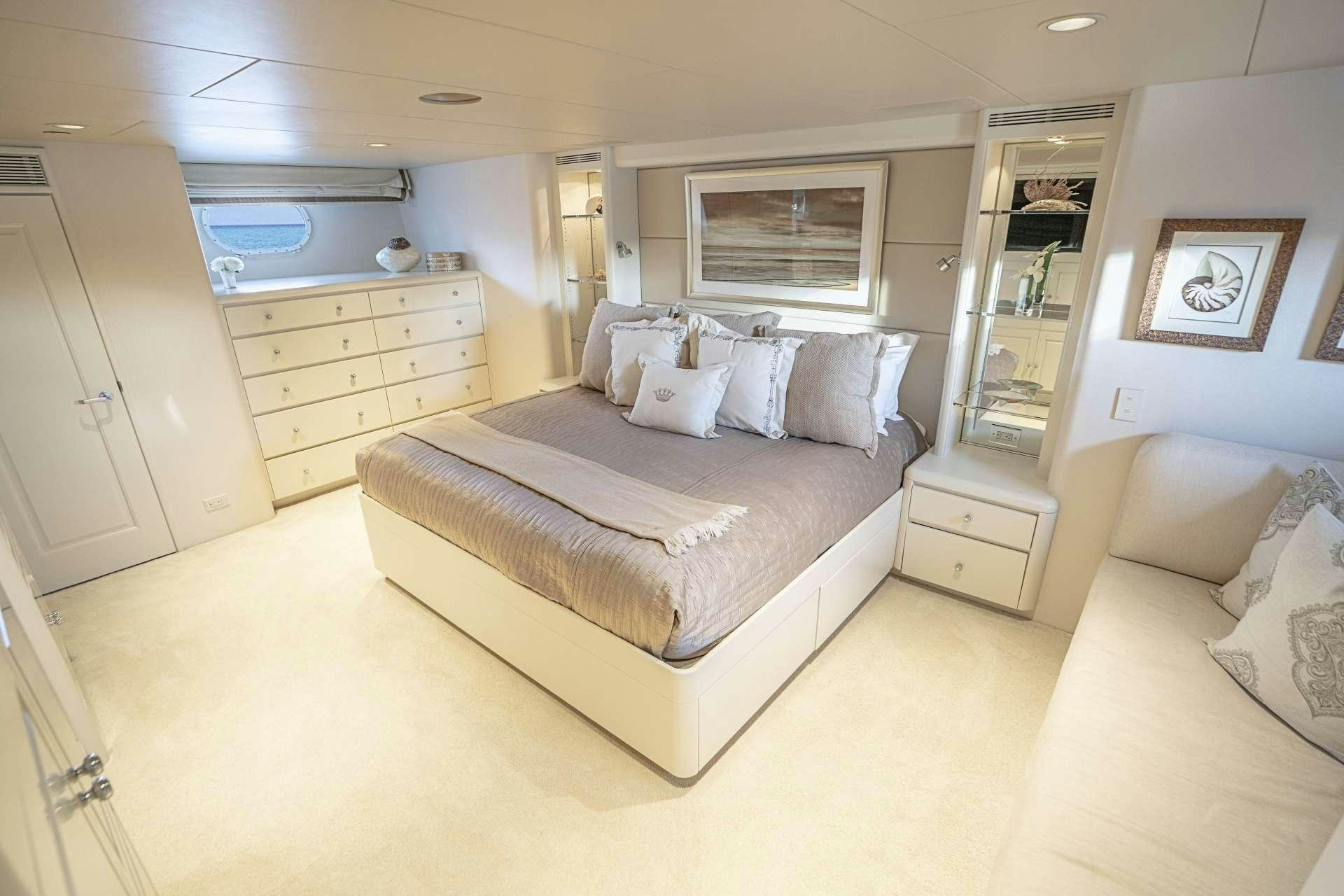 a bedroom with a bed and a bookcase aboard CHERISH Yacht for Charter