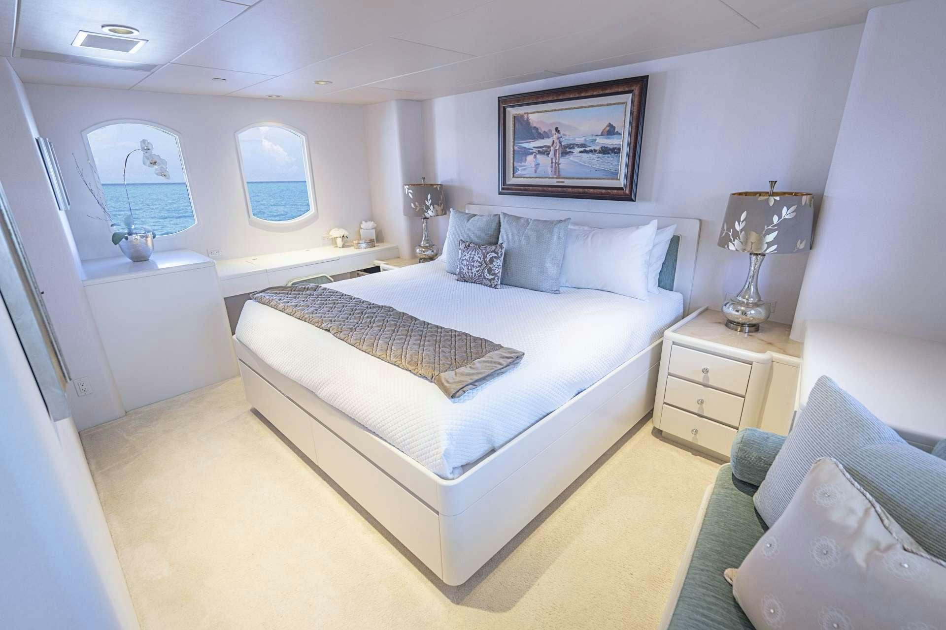 a bedroom with a bed and a chair aboard CHERISH Yacht for Charter