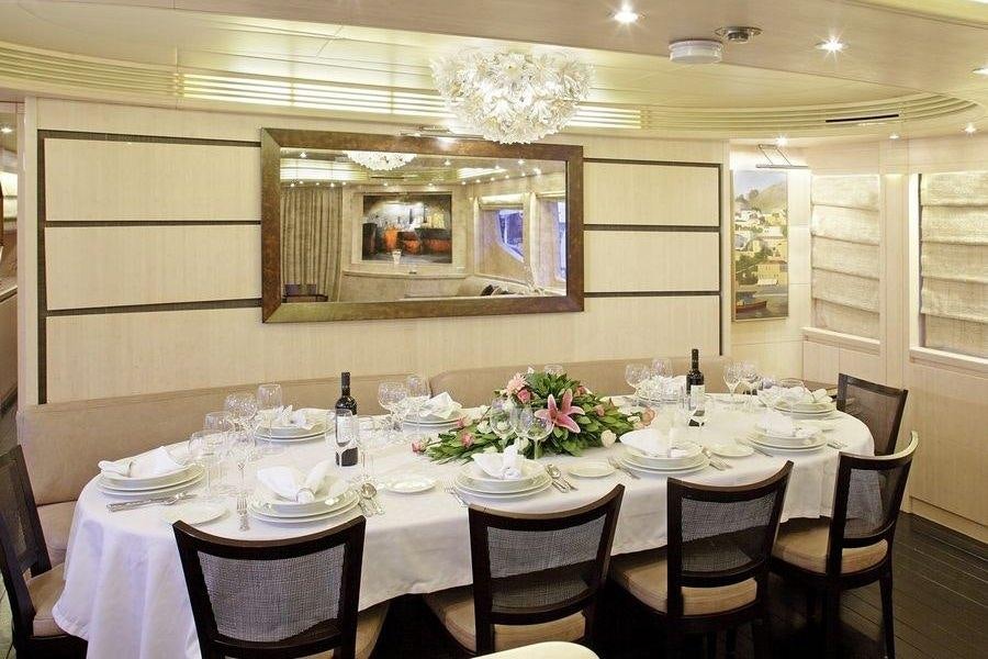 a dining room table set for a dinner party aboard GLAROS Yacht for Charter