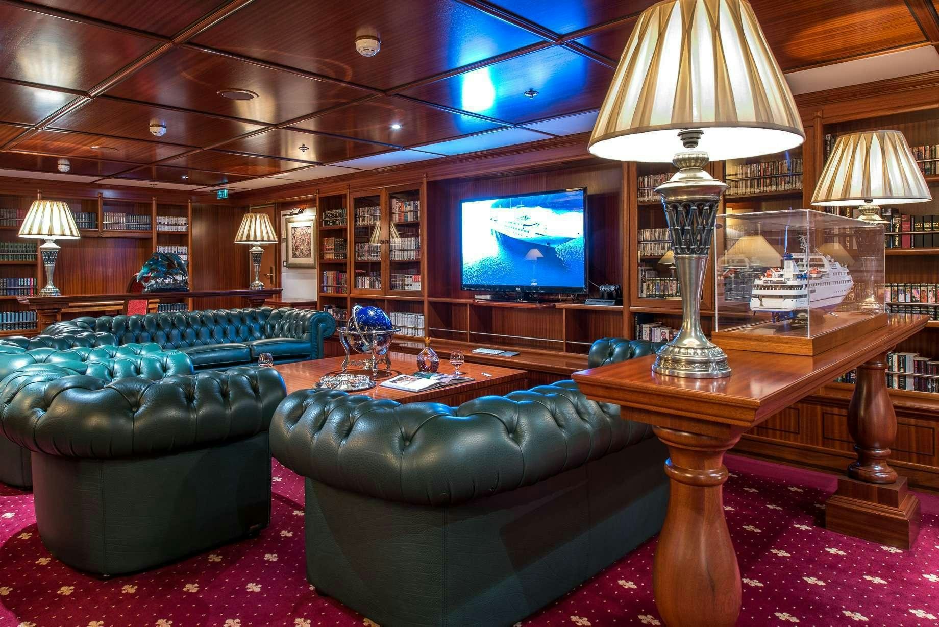 a room with a couch and a television aboard LAUREN L Yacht for Charter