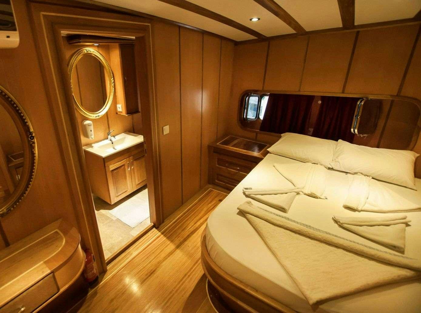 a hotel room with a bed and a mirror aboard TERSANE 8 Yacht for Charter