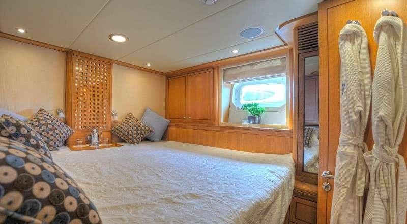 a bedroom with a bed and a window aboard MARGARET ANN Yacht for Charter