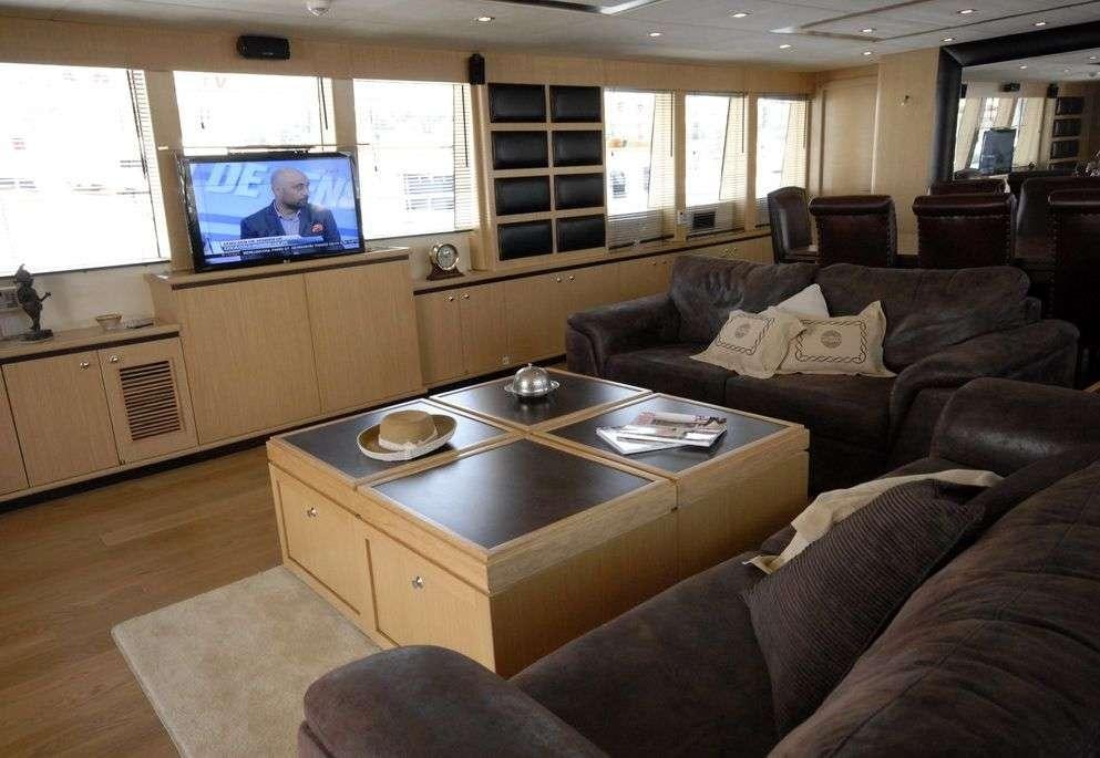 a living room with a table and a tv aboard SMYRNA Yacht for Charter