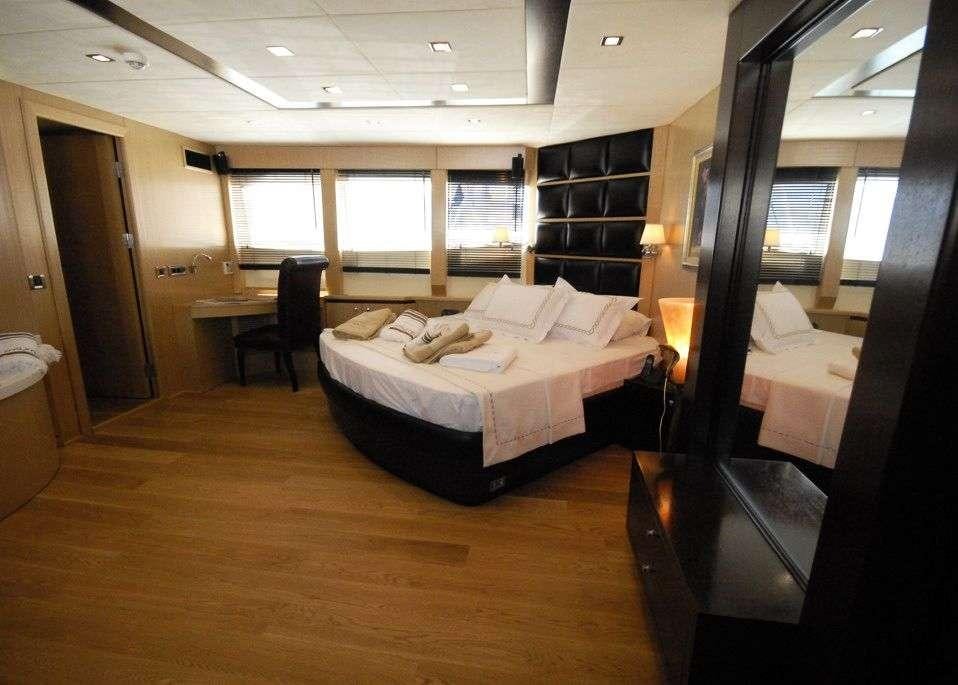a bedroom with a bed and a bookcase aboard SMYRNA Yacht for Charter
