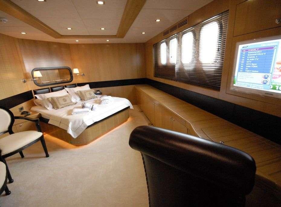 a room with a bed and a chair aboard SMYRNA Yacht for Charter