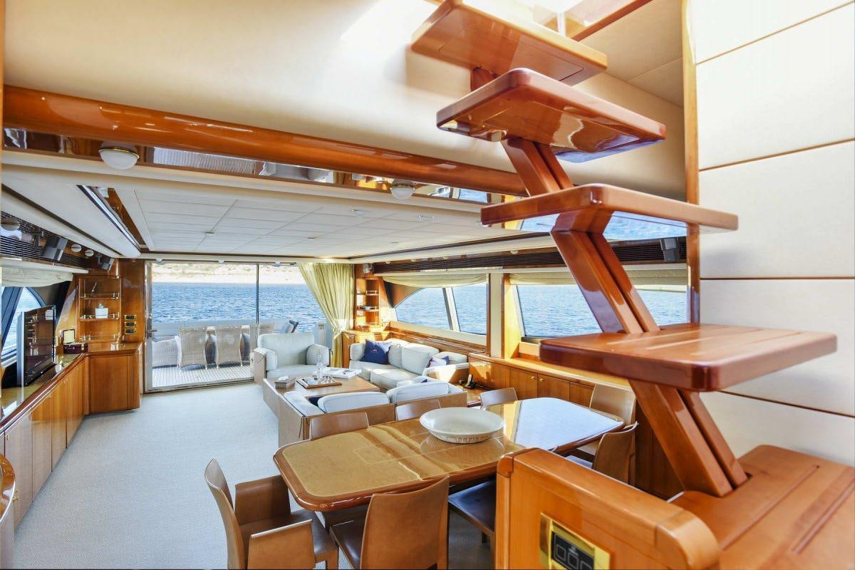 a room with a table chairs and a large window aboard DAY OFF Yacht for Charter