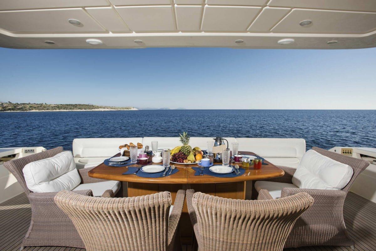 a table with chairs and a view of the ocean aboard DAY OFF Yacht for Charter
