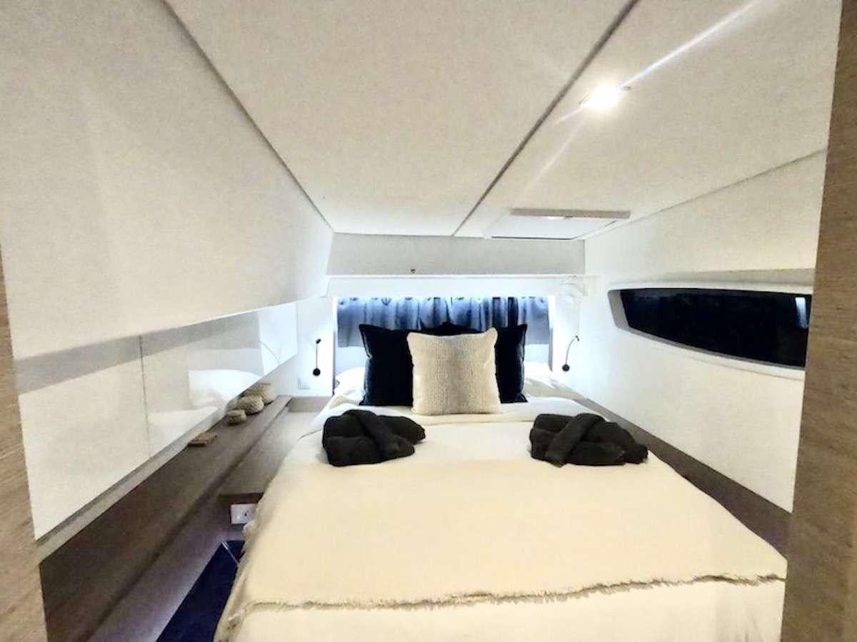a bed with white sheets aboard CHAMPAGNE Yacht for Charter