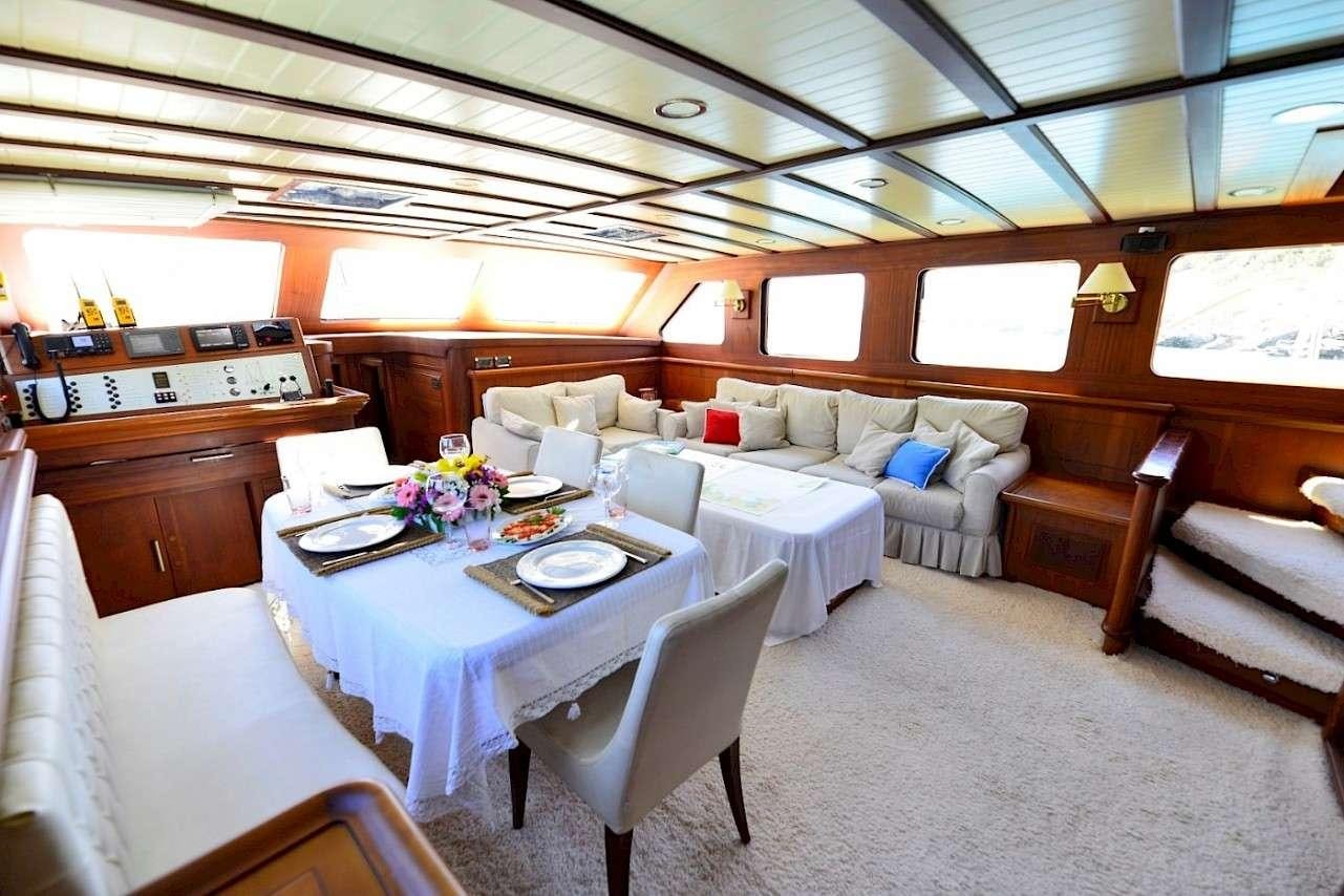 a room with a table chairs and a couch aboard MIA 1 Yacht for Charter