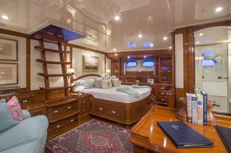 a bedroom with a bed and a desk aboard WHISPER Yacht for Charter