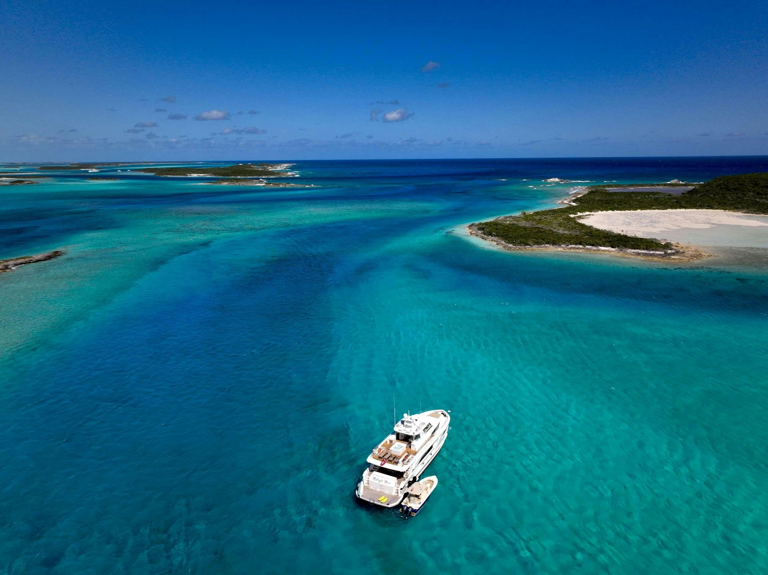 a boat on the water with Lady Musgrave Island in the background aboard MIDNIGHT MOON Yacht for Charter