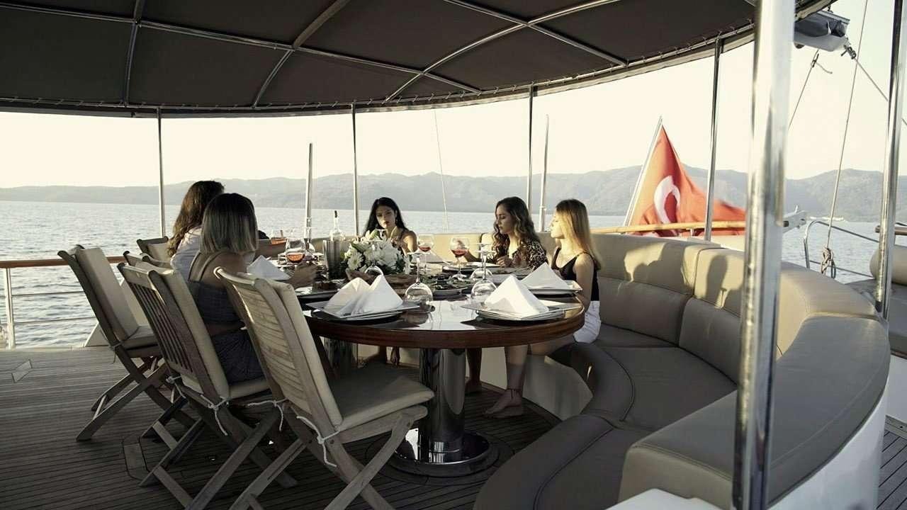 a group of people sitting around a table aboard SADIYE HANIM Yacht for Charter