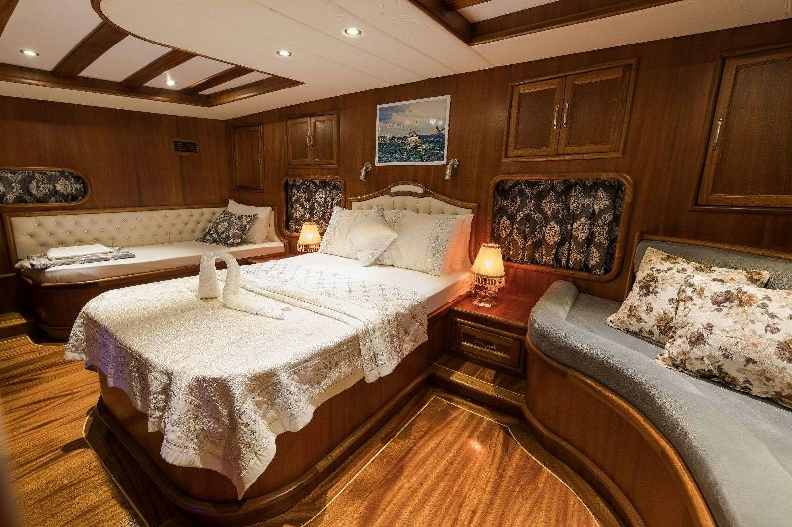 a room with a bed and a couch aboard KORAY EGE Yacht for Charter