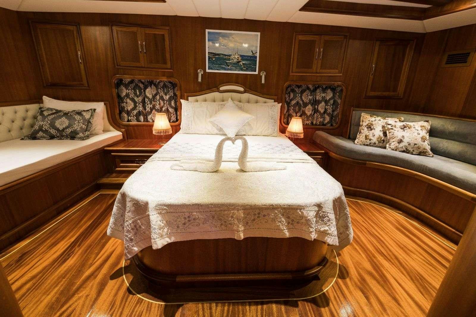 a room with a bed and a couch aboard KORAY EGE Yacht for Charter