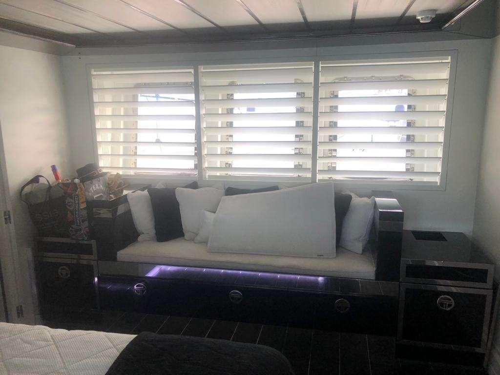 a living room with a couch and a window aboard DOUBLE SHOT Yacht for Charter