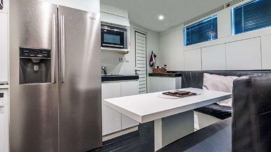 a kitchen with a refrigerator and a table aboard DOUBLE SHOT Yacht for Charter