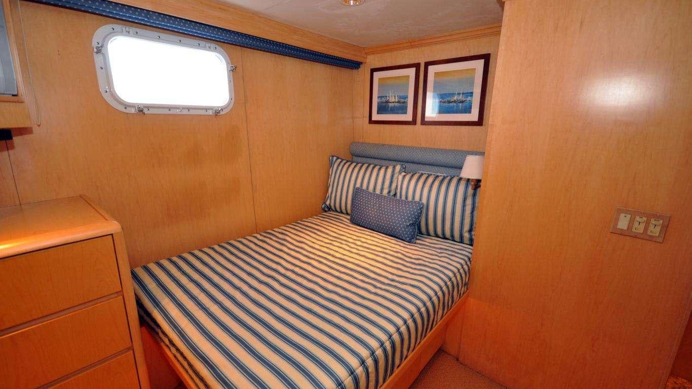 a bedroom with a bed and a window aboard LUCKY STARS Yacht for Charter