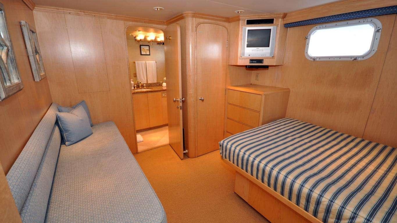 a room with a bed and a television aboard LUCKY STARS Yacht for Charter