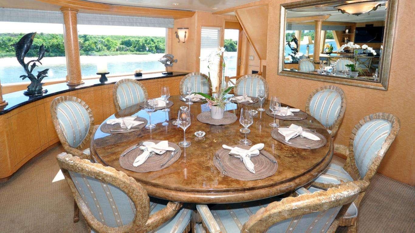 a dining table with chairs and a view of the outside aboard LUCKY STARS Yacht for Charter