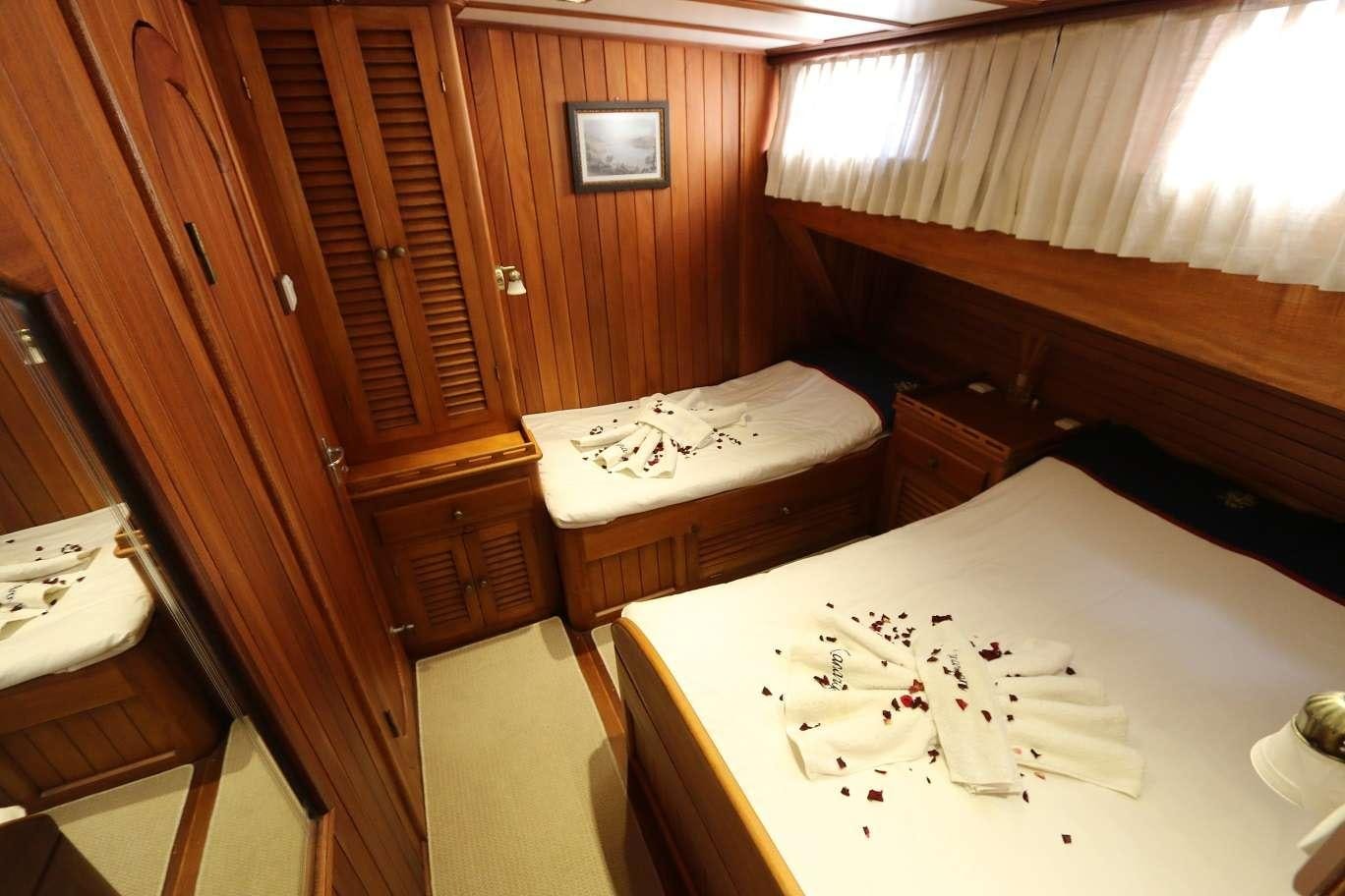 a table with a chair and a bed in a room aboard KANARYA Yacht for Charter
