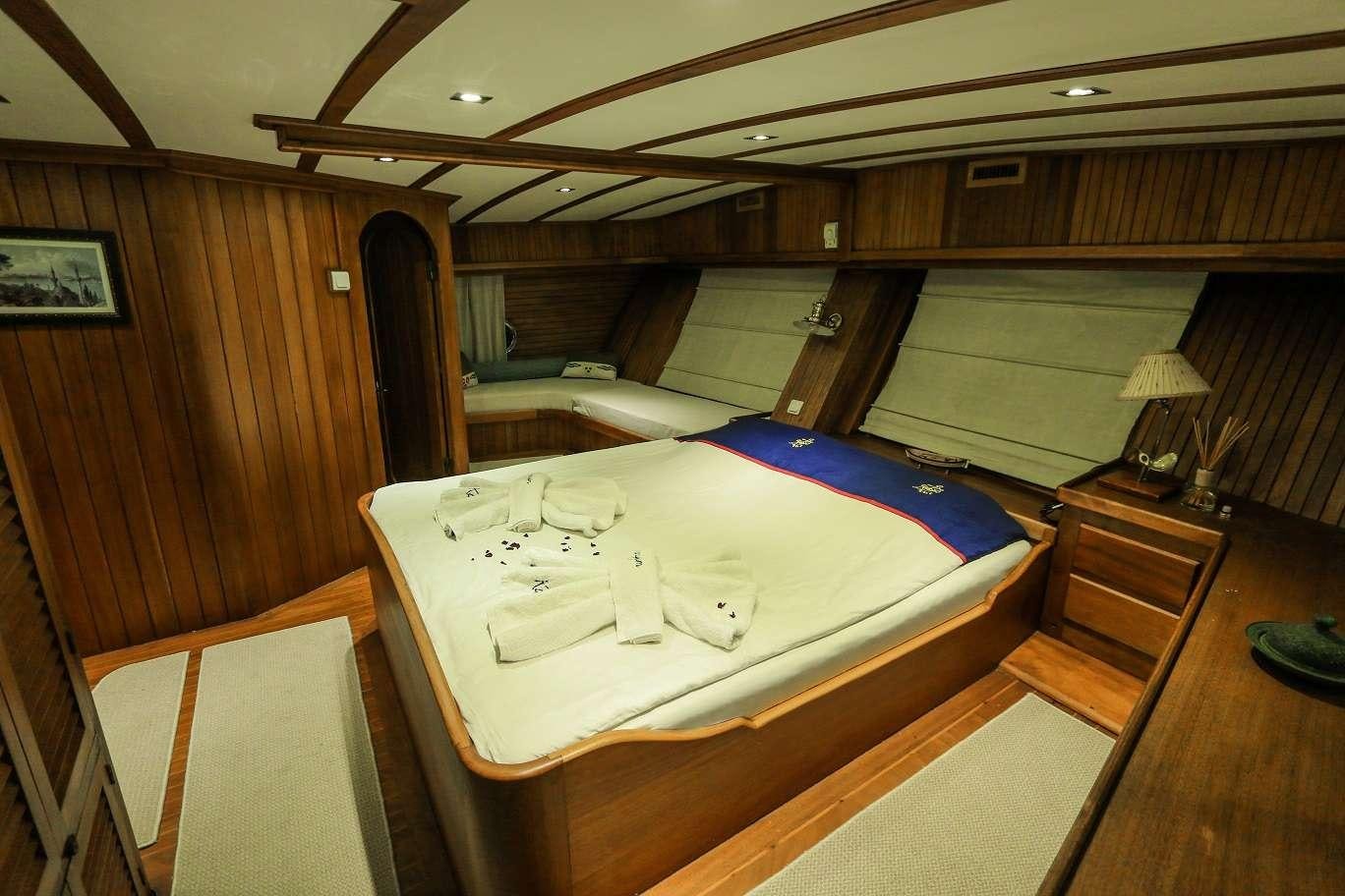 a room with a bed and a table aboard KANARYA Yacht for Charter