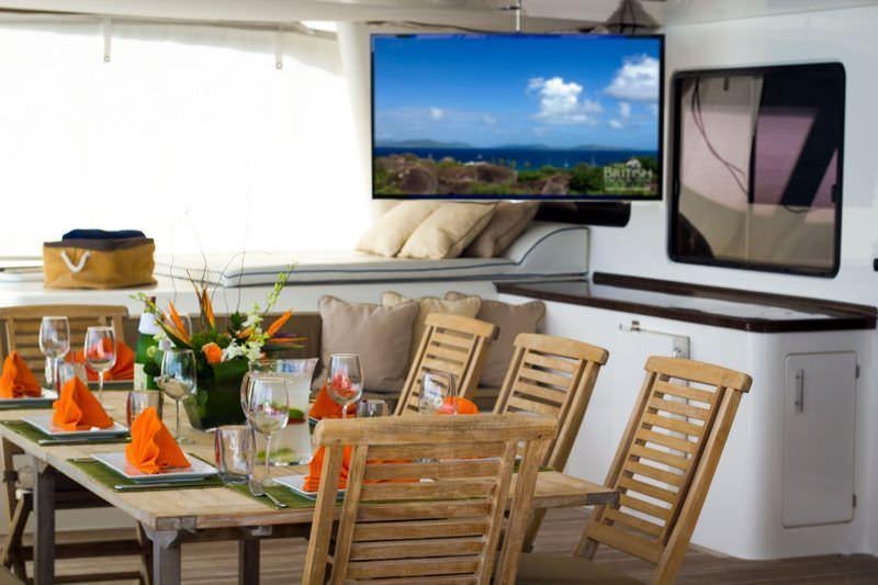 a dining room with a television on the wall aboard KINGS RANSOM Yacht for Charter