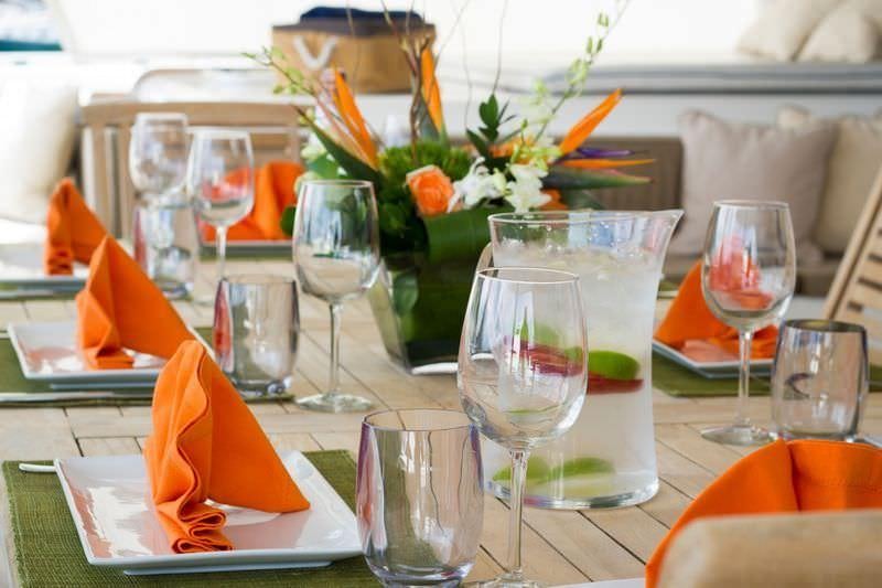 a table with wine glasses and a vase with flowers aboard KINGS RANSOM Yacht for Charter