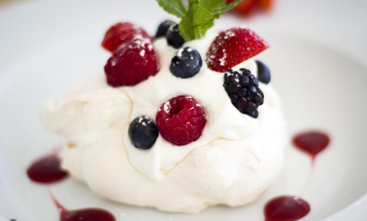 a white cake with fruit on top aboard KINGS RANSOM Yacht for Charter