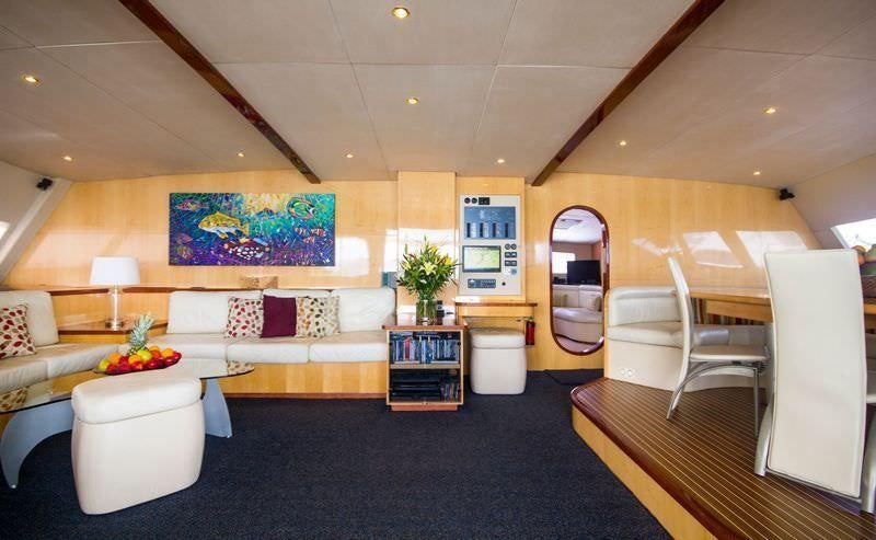 a living room with a large blue rug and a large mirror aboard KINGS RANSOM Yacht for Charter