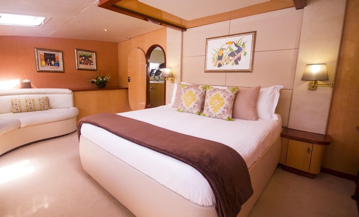 a bed with a white bed spread aboard KINGS RANSOM Yacht for Charter