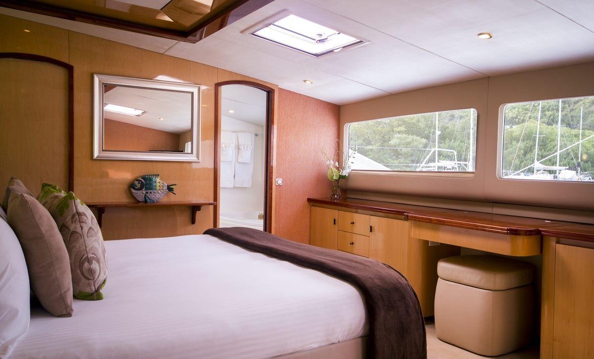 a bedroom with a bed and a desk aboard KINGS RANSOM Yacht for Charter