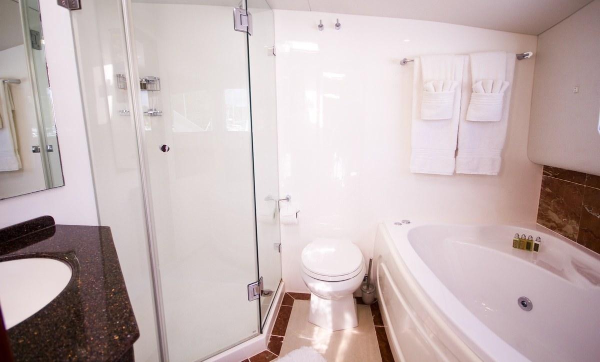 a bathroom with a sink toilet and bathtub aboard KINGS RANSOM Yacht for Charter