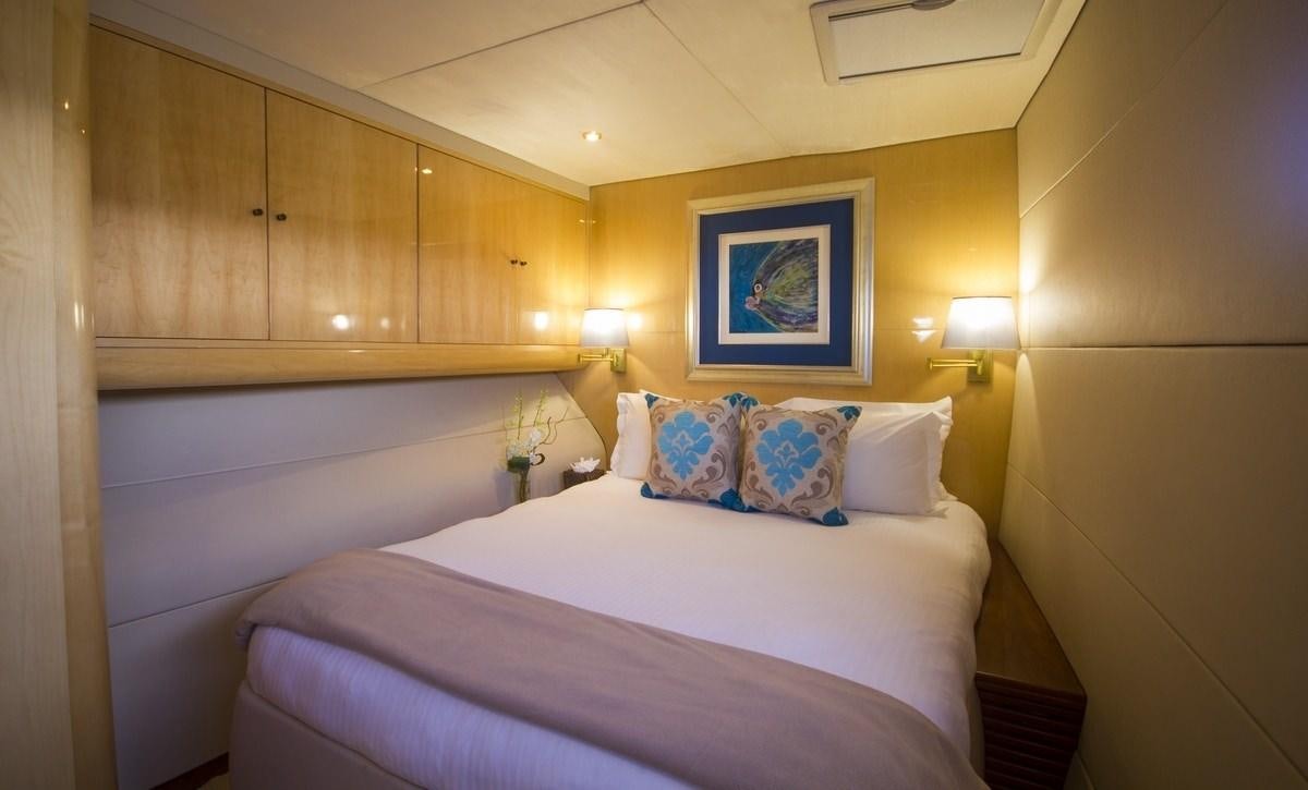 a room with a bed and a painting on the wall aboard KINGS RANSOM Yacht for Charter