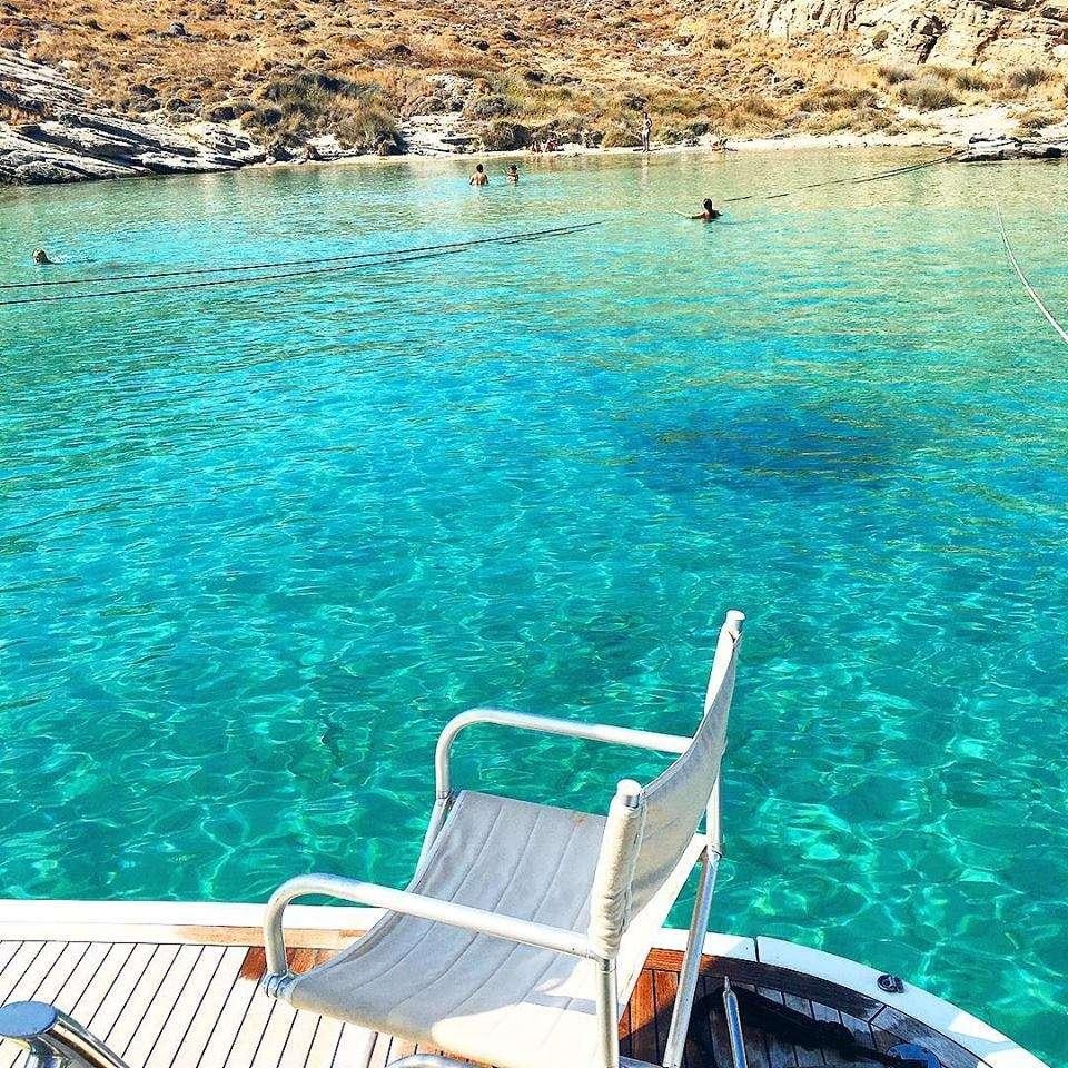 a chair on a deck overlooking a body of water aboard AVENTURA II Yacht for Charter