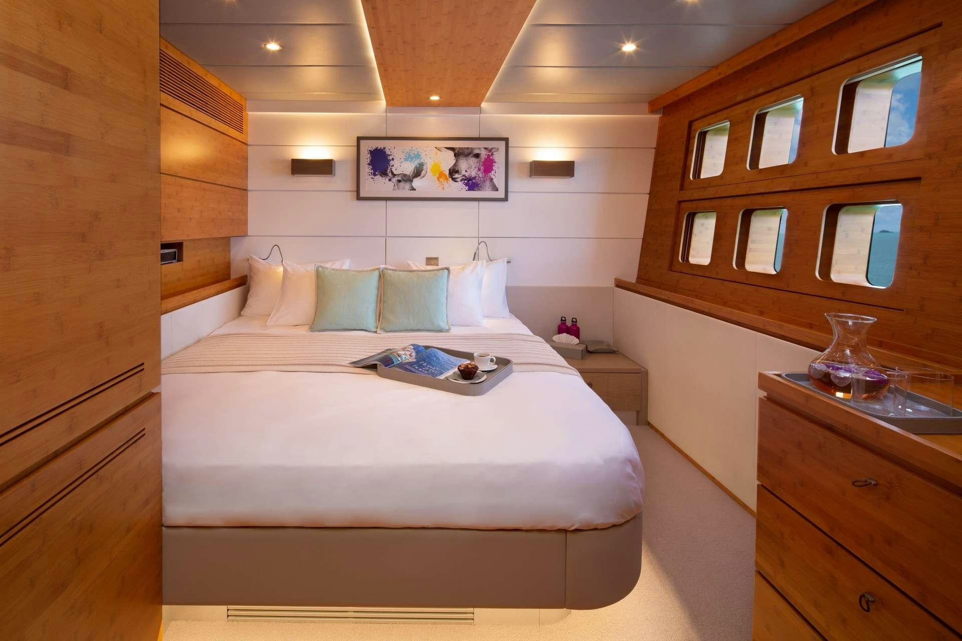 a bed with a white sheet and pillows on it aboard CHE Yacht for Charter