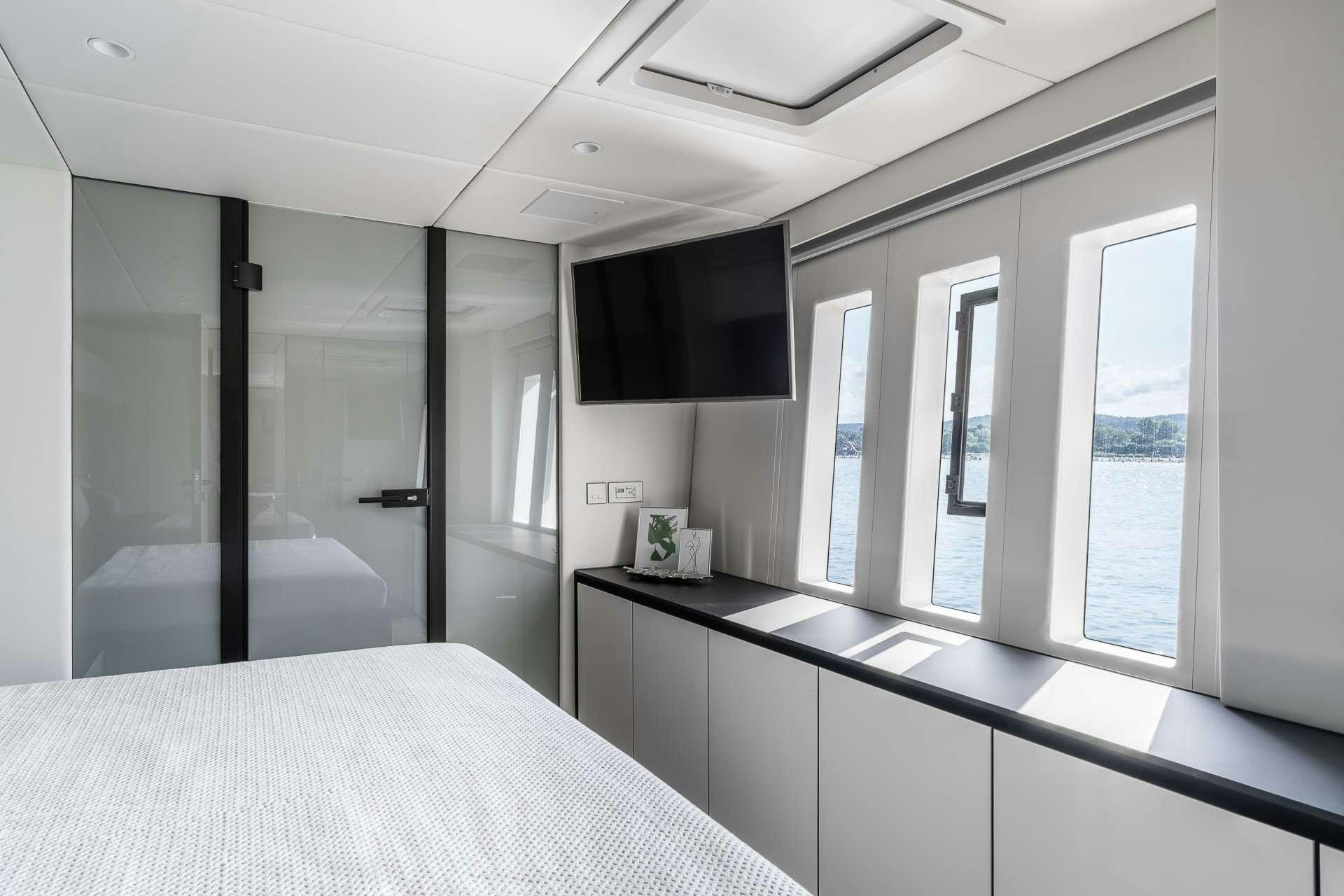 a room with a bed and a tv on the wall aboard ABOVE AND BEYOND Yacht for Charter