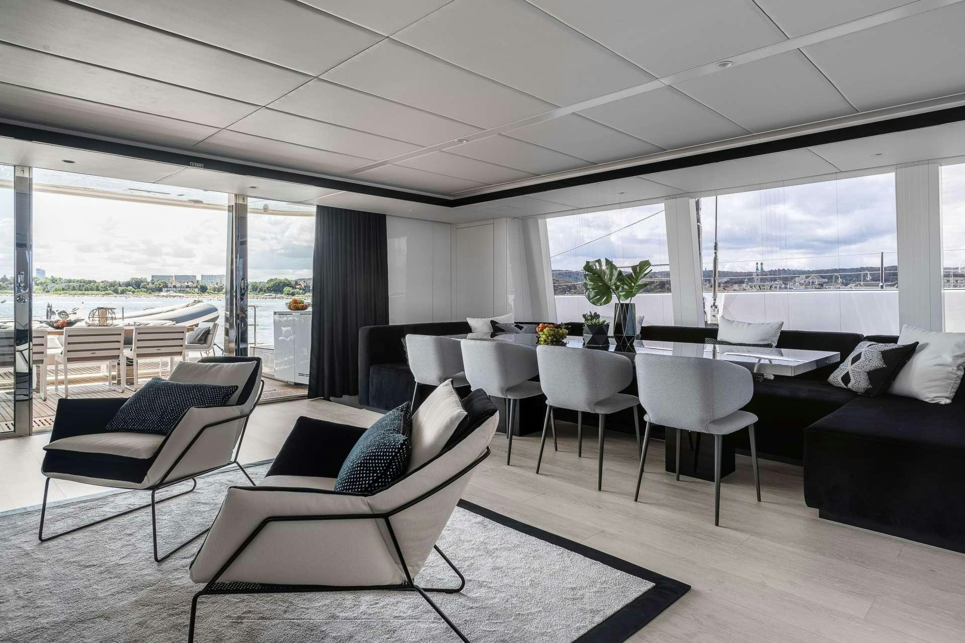 a room with a table chairs and a couch aboard ABOVE AND BEYOND Yacht for Charter