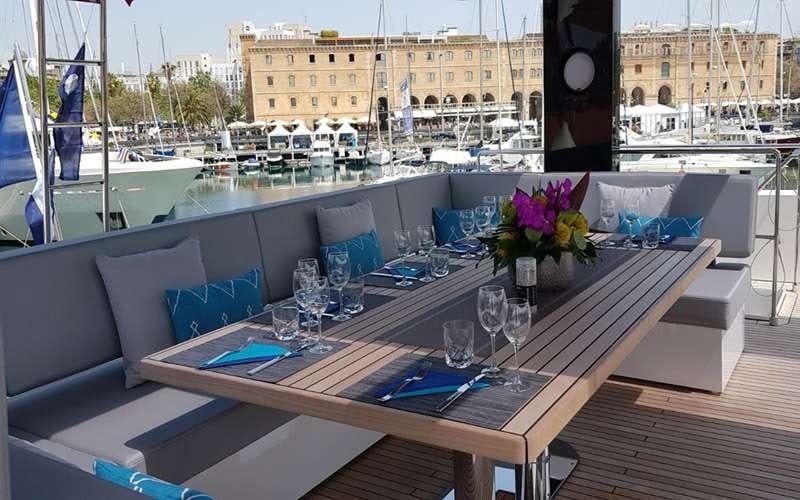 a table with wine glasses and a couch on it aboard MAYRILOU Yacht for Charter
