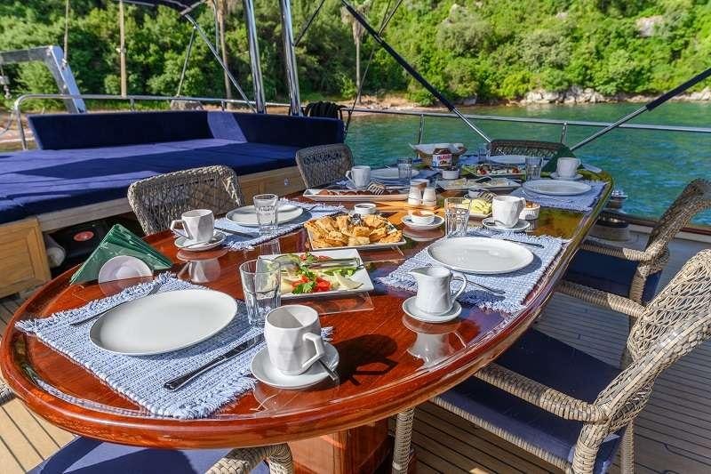 a table with plates and cups on it aboard VIVA SHIRA Yacht for Charter