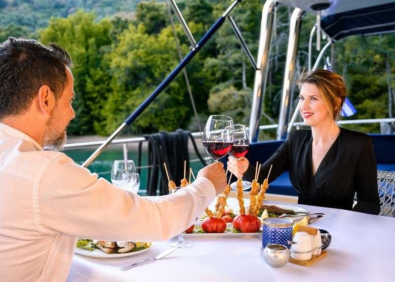a man and a woman enjoying a meal at a table aboard VIVA SHIRA Yacht for Charter