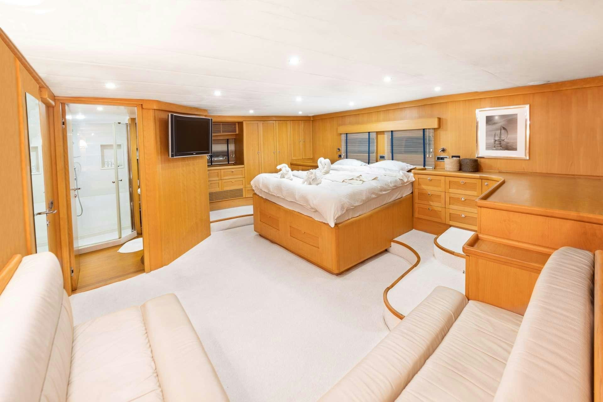 a bedroom with a bed and a television aboard VIVA SHIRA Yacht for Charter