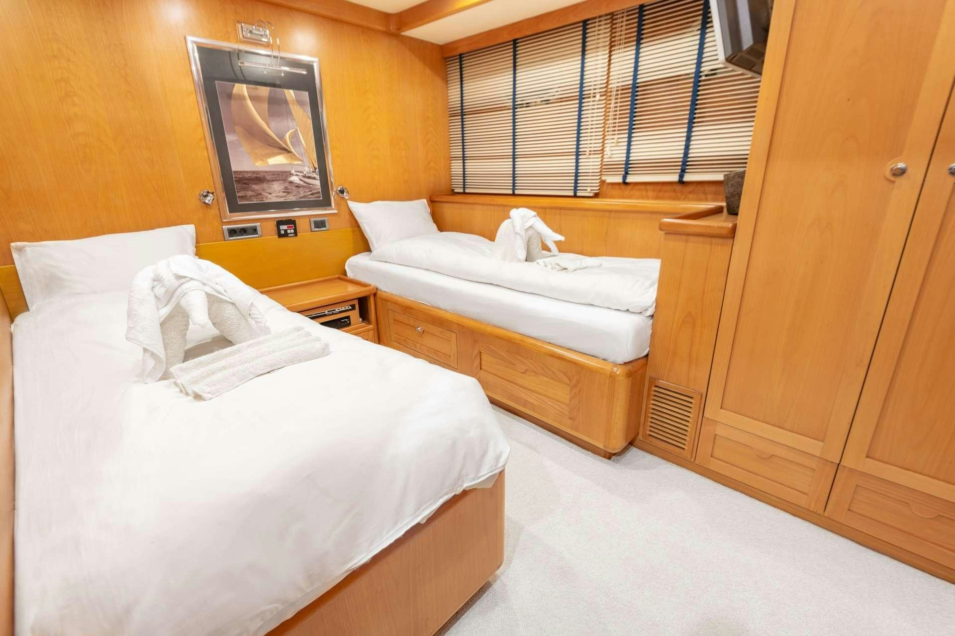 a room with beds and a window aboard VIVA SHIRA Yacht for Charter