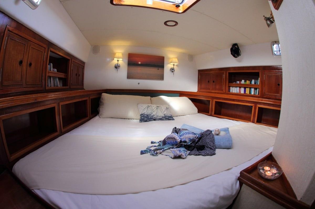 a bed with a white sheet and pillows on it aboard EMILY MORGAN Yacht for Charter