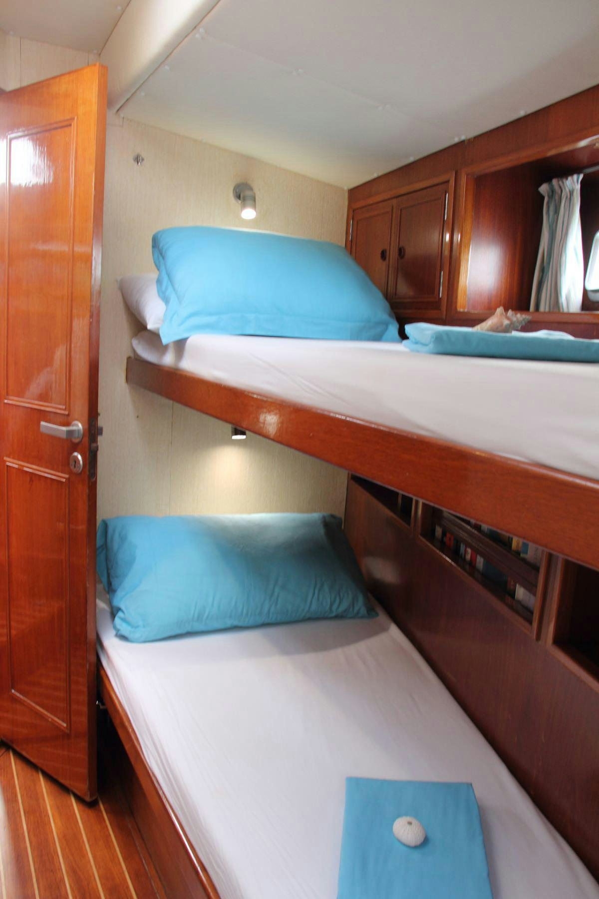 a bed with blue sheets aboard EMILY MORGAN Yacht for Charter
