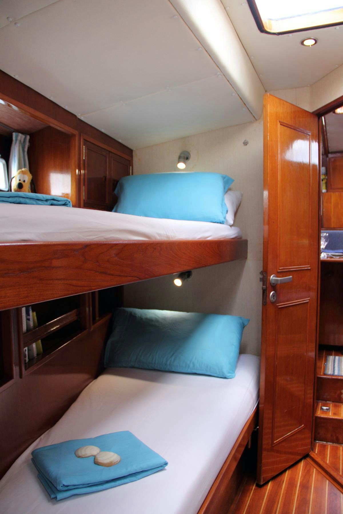 a bed with a blue pillow aboard EMILY MORGAN Yacht for Charter