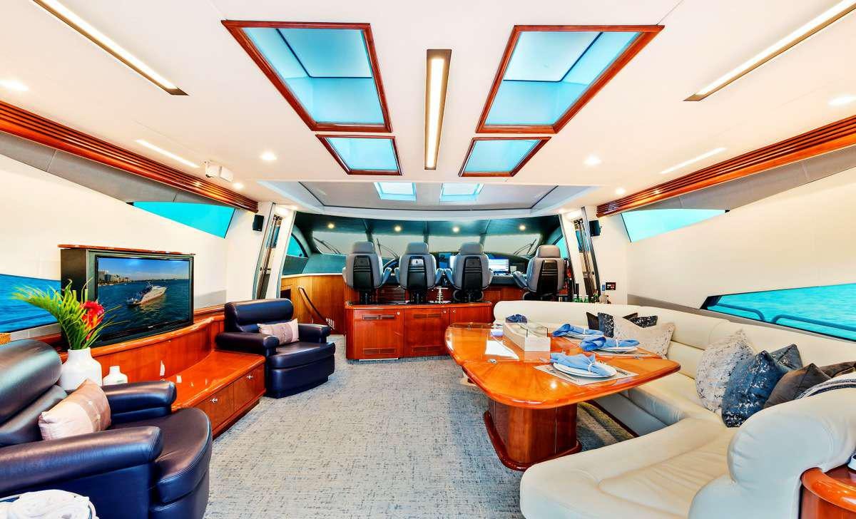 a room with a table chairs and a television aboard PRIVEE Yacht for Charter