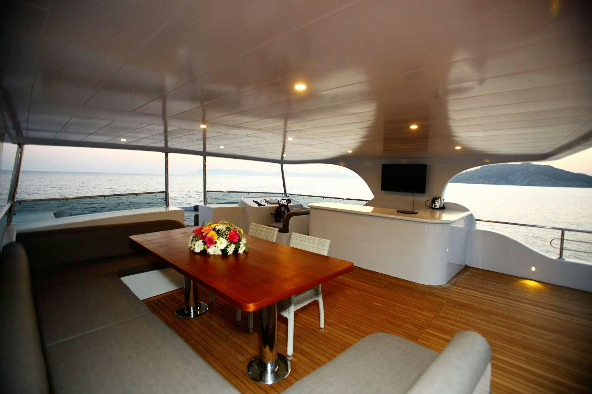 a room with a table and a tv aboard CROCUS Yacht for Charter