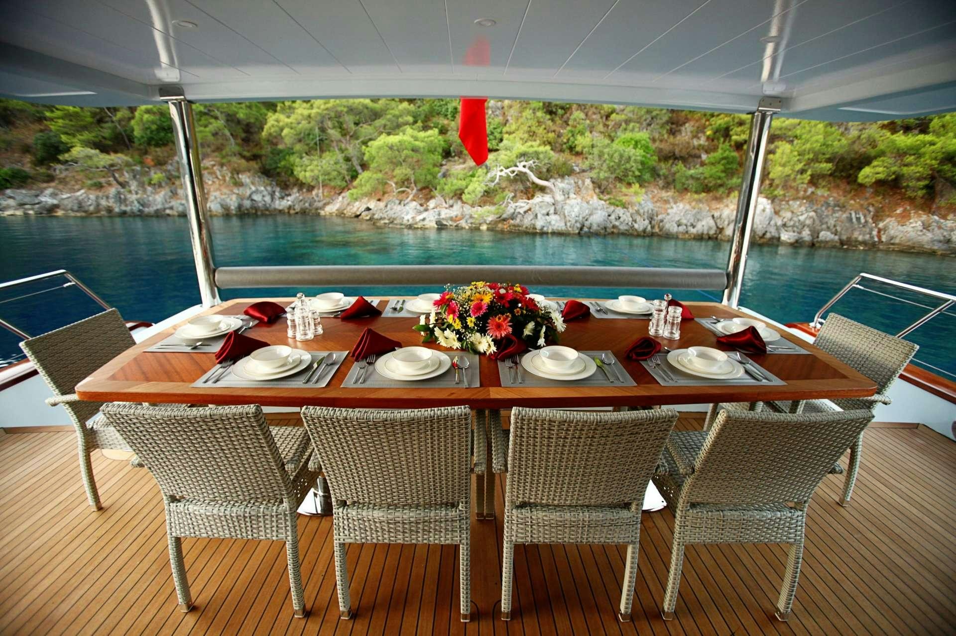 a table set for a dinner on a boat aboard CROCUS Yacht for Charter